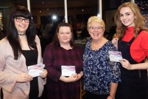 Adult members stand with service awards