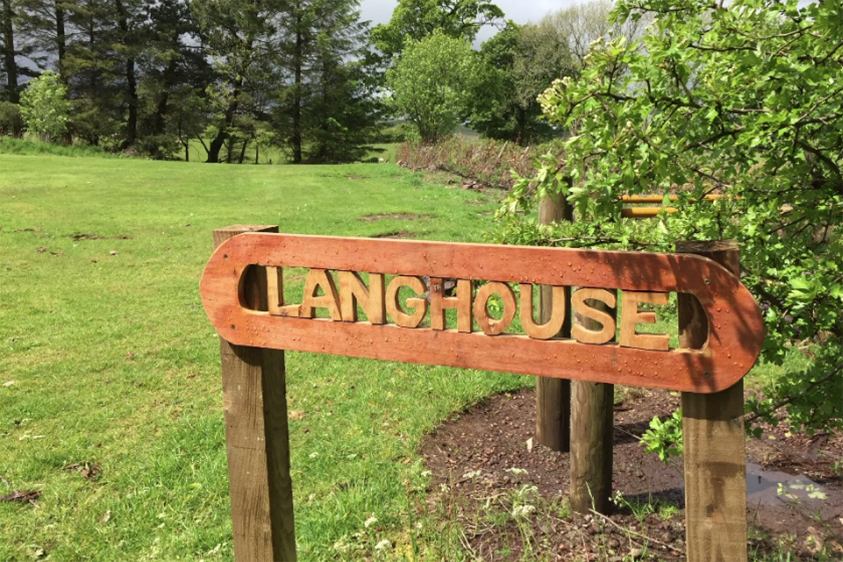 Wooden sign with text "LANGHOUSE" carved out